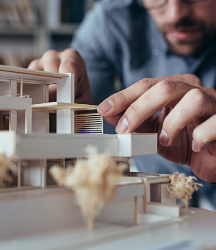 man building a house model